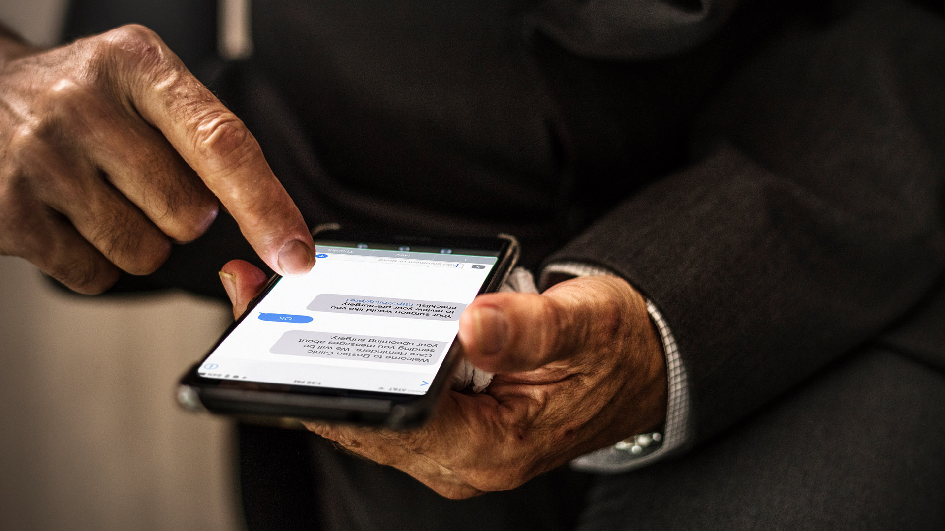 Patient interacting with Philips Patient Management Solution on a smartphone over two screens.