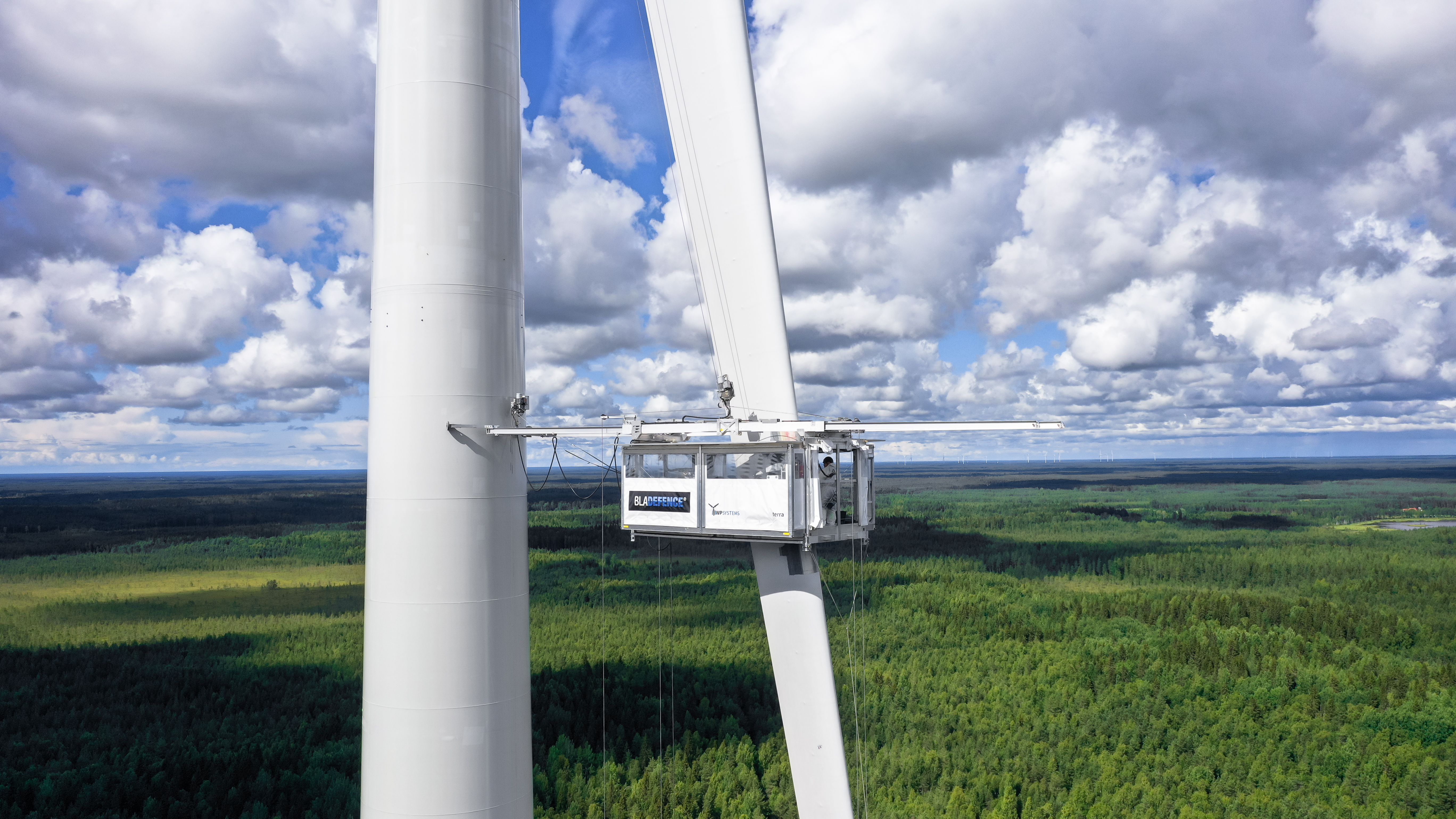Bladefence technicians carrying out structural repairs to blades on a suspended platform in Raahe