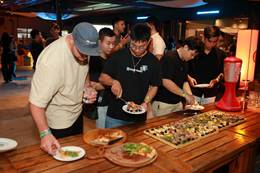 A group of people standing around a table with food on plates  AI-generated content may be incorrect.