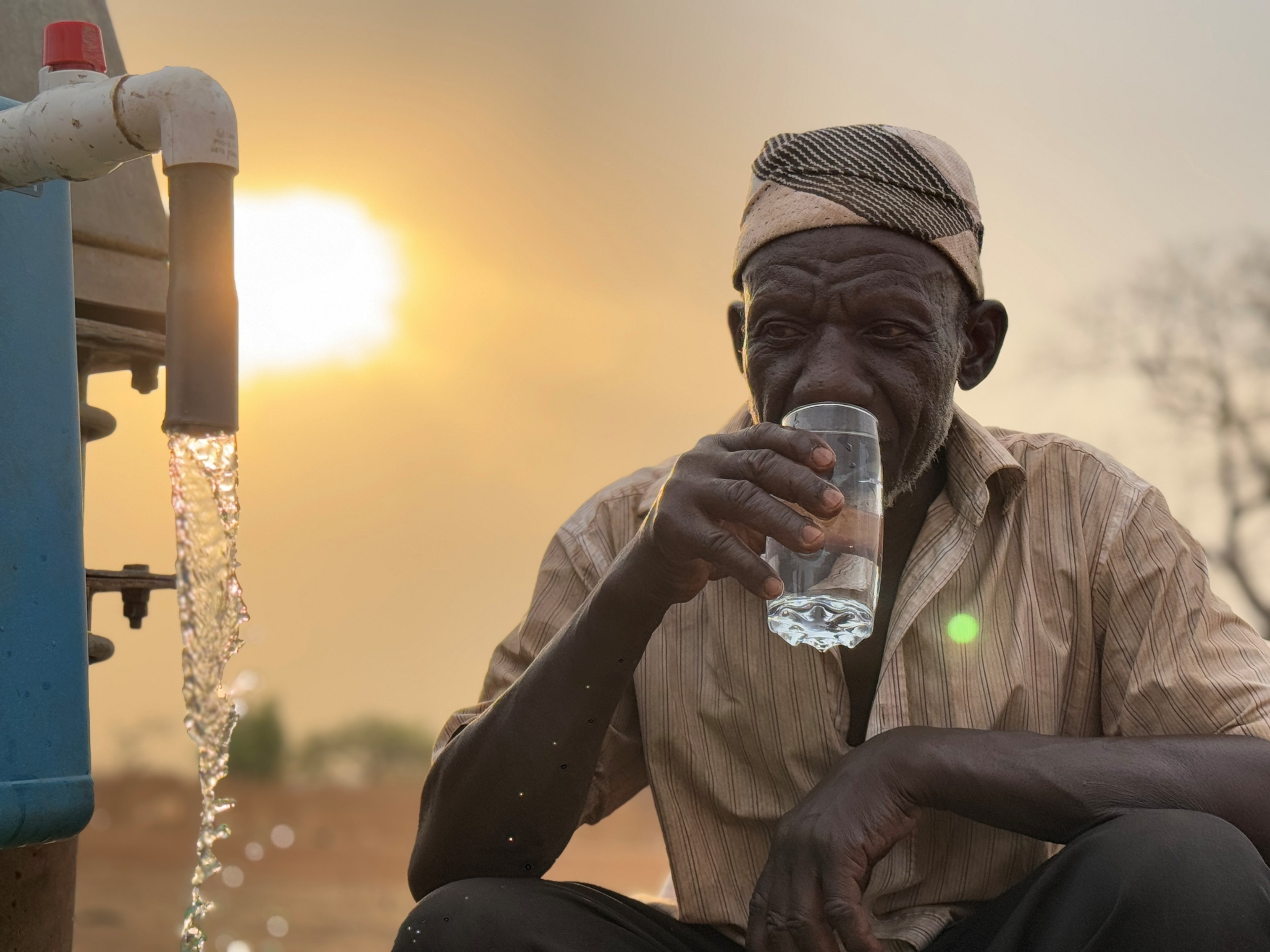 Safe Drinking Water in Tanzania: A community member in Tanzania drinks filtered water supplied by the BAR Element 15 system.