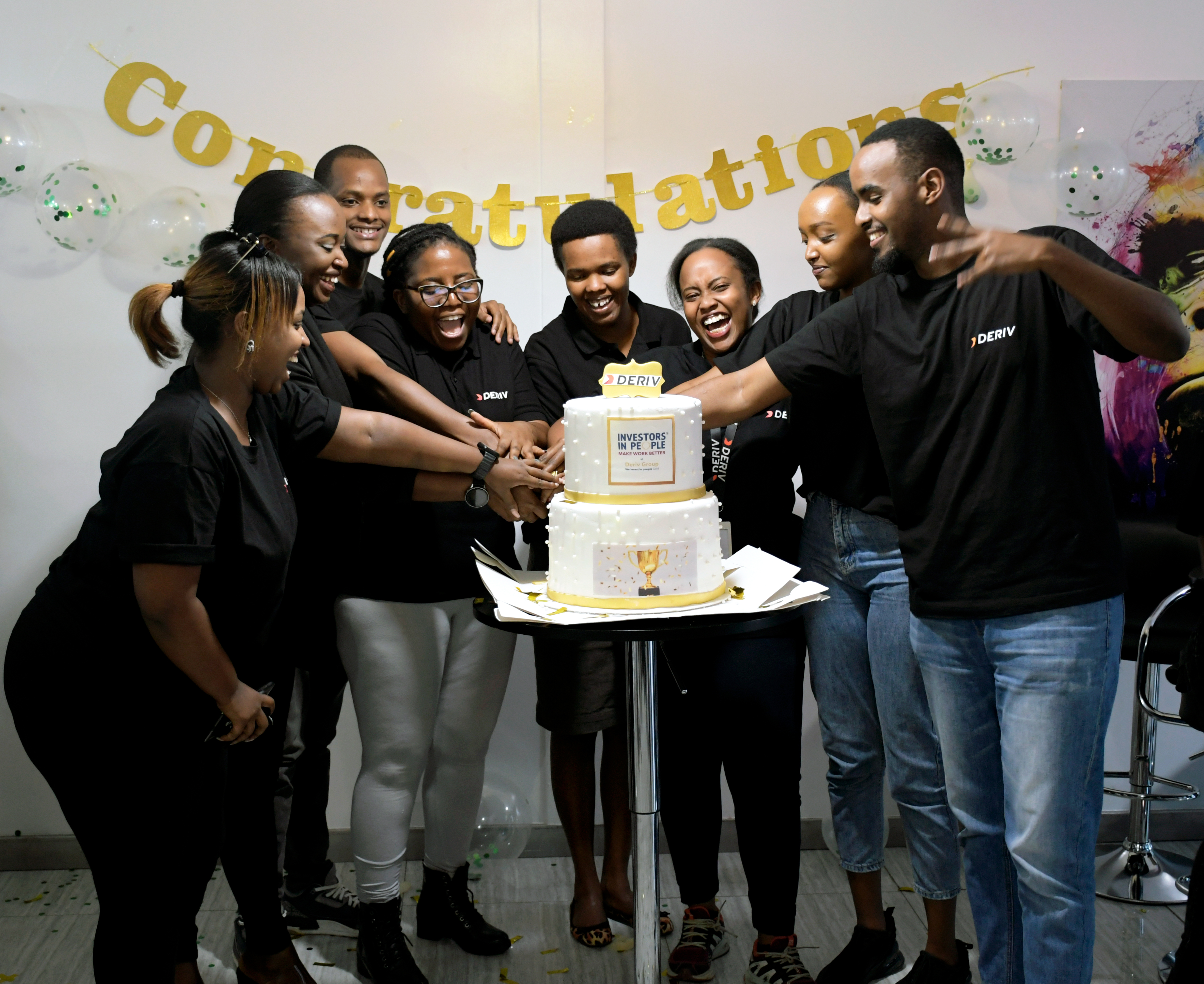 Derivians cutting cake to celebrate the IIP gold status