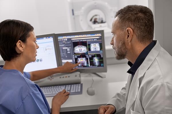 Philips CT scanner operated by doctor and tech support in the control room
