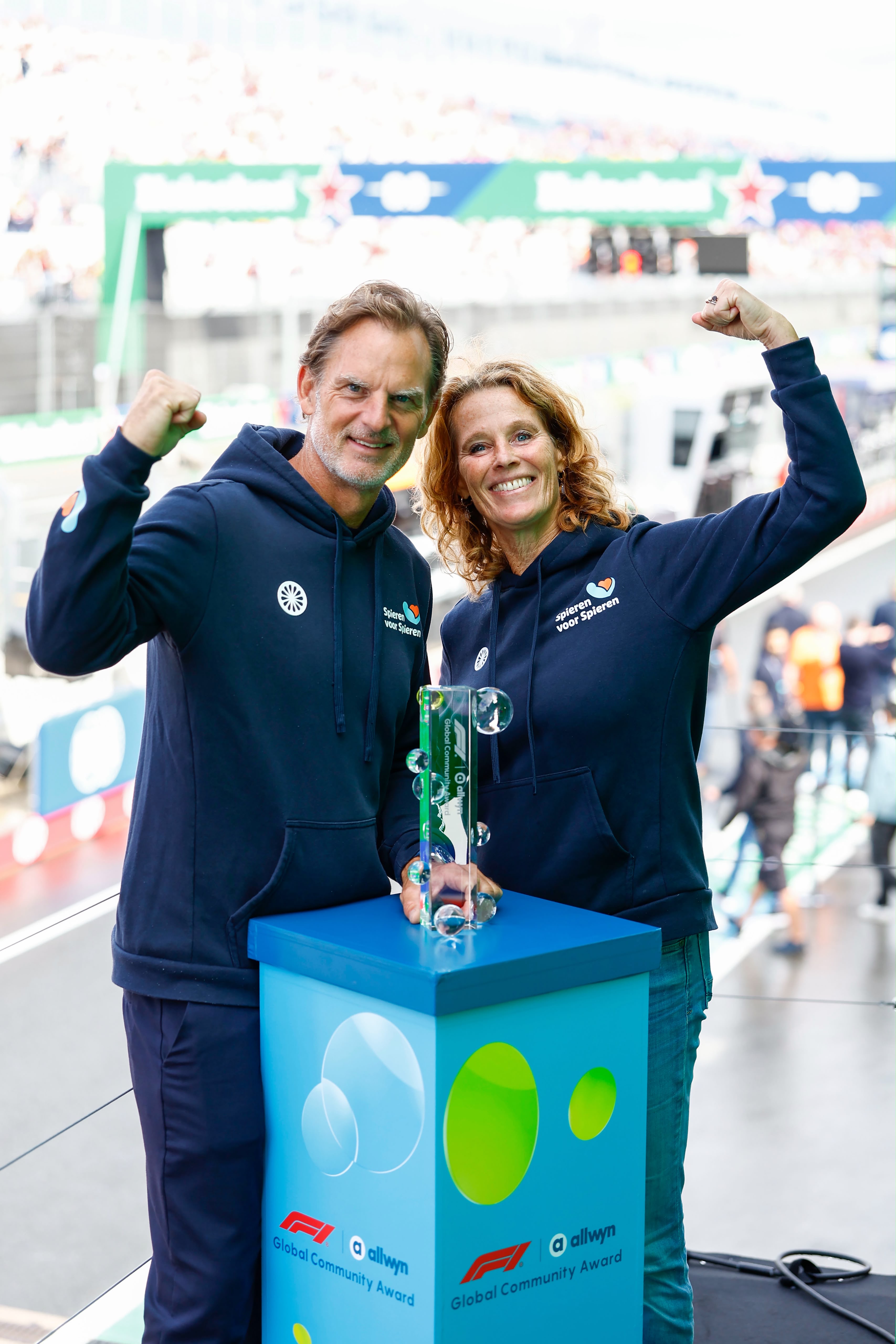 The F1® Allwyn Global Community Award 2026 trophy presented to Monique Maks (Director) and Ronald de Boer (former footballer and ambassador) of winnin